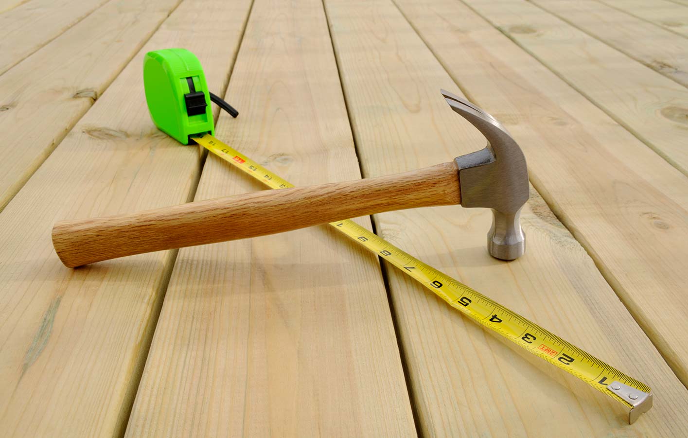 Hammer und Metermaß auf einer Holzterrasse 